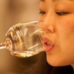 Mulher degusta bebida transparente em taça de vidro no Catad'Or 2021