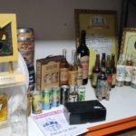 Mesa com diversas garrafas, quadros e outros item de colecionador de cachaças